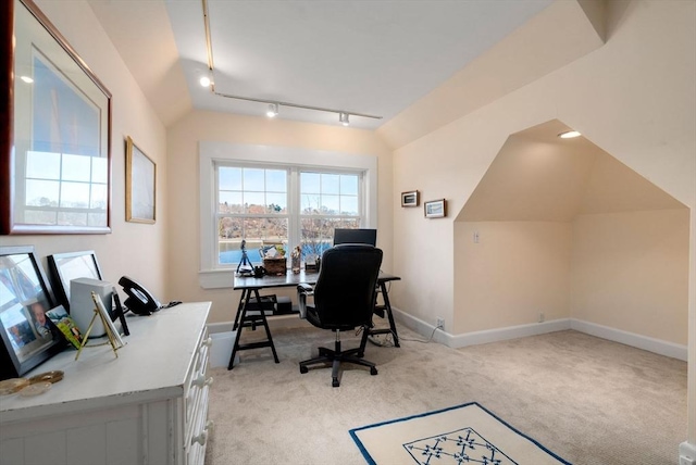 home office featuring lofted ceiling, baseboards, light colored carpet, and rail lighting