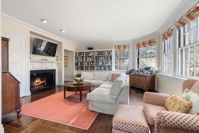 interior space with a wealth of natural light, a fireplace with flush hearth, crown molding, and wood finished floors