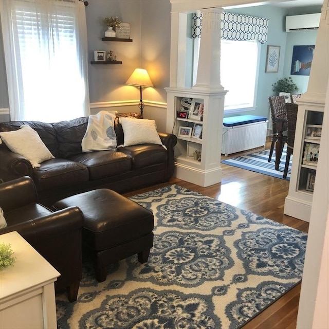 14 Highland St, Clinton, MA 01510 - living room featuring a wall unit AC, healthy amount of natural light, wood finished floors, and decorative columns
