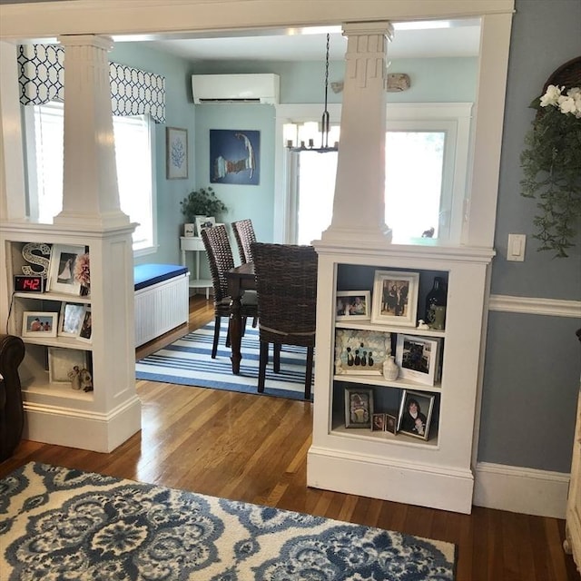 14 Highland St, Clinton, MA 01510 - dining space featuring an AC wall unit, decorative columns, a chandelier, and wood finished floors