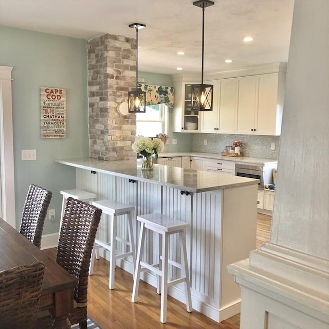 14 Highland St, Clinton, MA 01510 - kitchen featuring white cabinets, a breakfast bar area, light wood-style flooring, tasteful backsplash, and recessed lighting