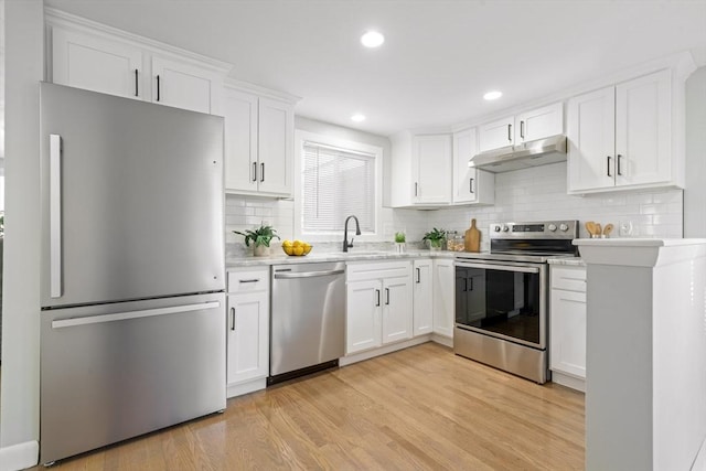 kitchen featuring stainless steel appliances, white cabinetry, sink, and light wood-type flooring