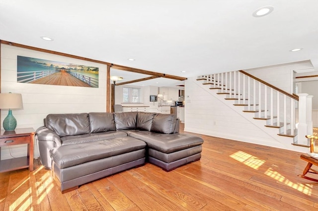 living area featuring light wood-type flooring, stairs, and recessed lighting