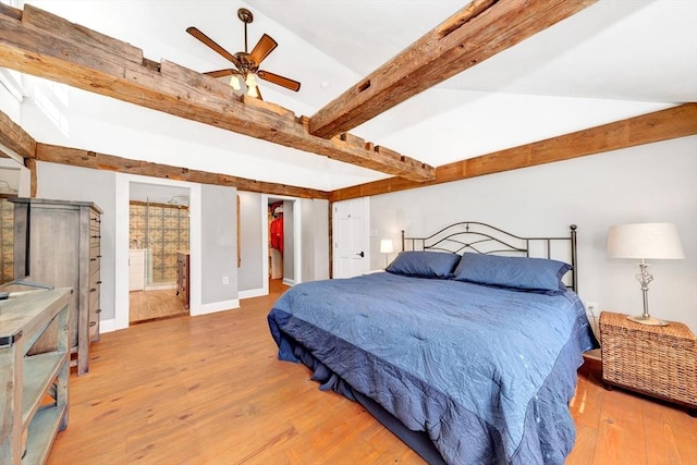 bedroom featuring hardwood / wood-style flooring, connected bathroom, beam ceiling, and baseboards