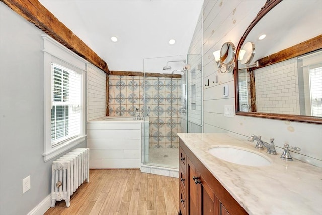 full bath with radiator heating unit, vanity, a shower stall, wood finished floors, and a bath