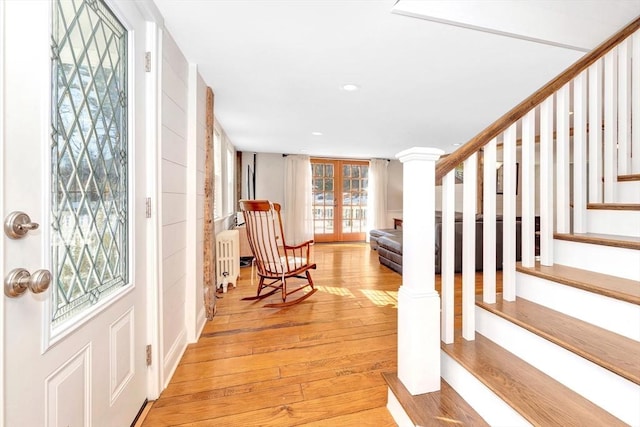 foyer featuring stairs, light wood-type flooring, and radiator