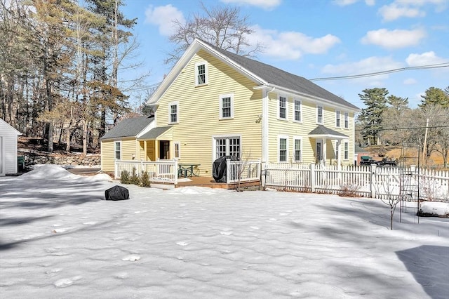 snow covered house with fence