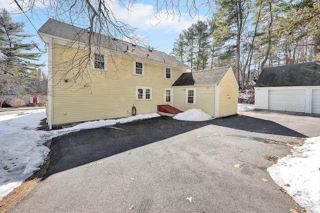 rear view of house featuring an outbuilding and a detached garage