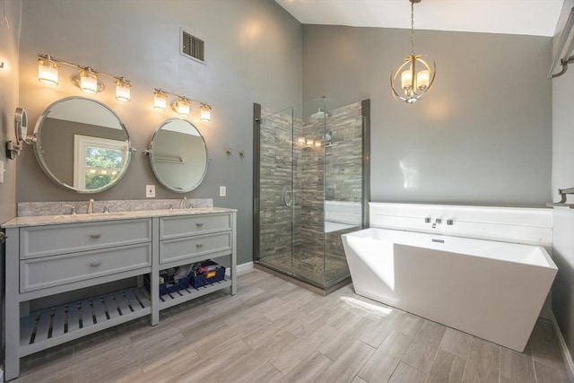5 Windsor Rd, Lynnfield, MA 01940 - full bathroom with high vaulted ceiling, double vanity, a freestanding bath, a stall shower, and a chandelier