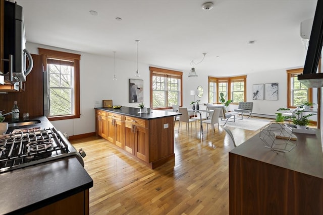 432 Norfolk St Unit 3B, Somerville, MA 02143 - kitchen with a peninsula, dark countertops, light wood-style floors, gas range, and hanging light fixtures