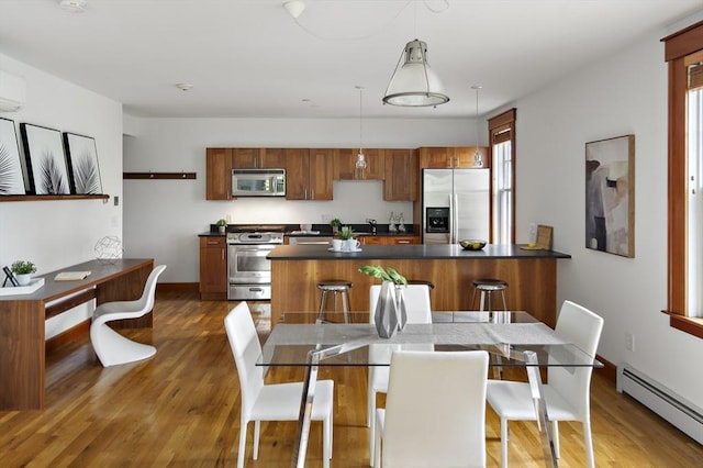 432 Norfolk St Unit 3B, Somerville, MA 02143 - dining area featuring baseboard heating, wood finished floors, and a wall unit AC