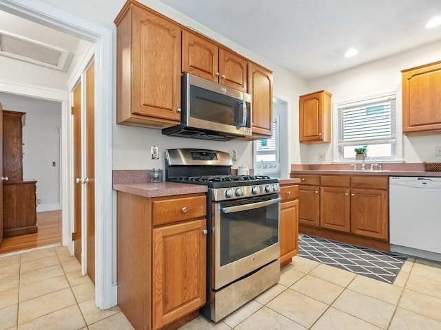 kitchen featuring light tile patterned floors, stainless steel appliances, and sink