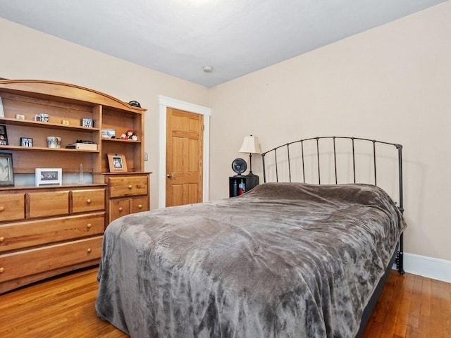 bedroom with dark hardwood / wood-style floors