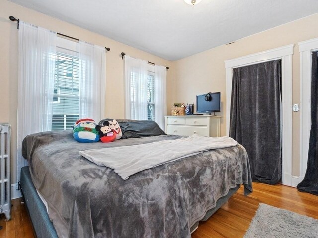 bedroom with radiator and light hardwood / wood-style floors