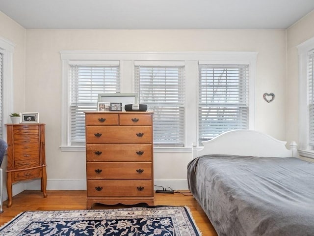 bedroom with light hardwood / wood-style floors and multiple windows