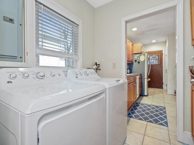 laundry room with cabinets, washing machine and dryer, light tile patterned floors, and electric panel