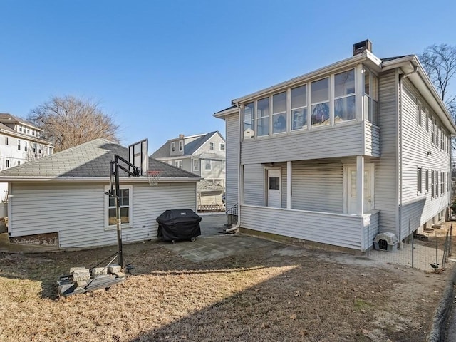 rear view of house featuring a patio area and a sunroom