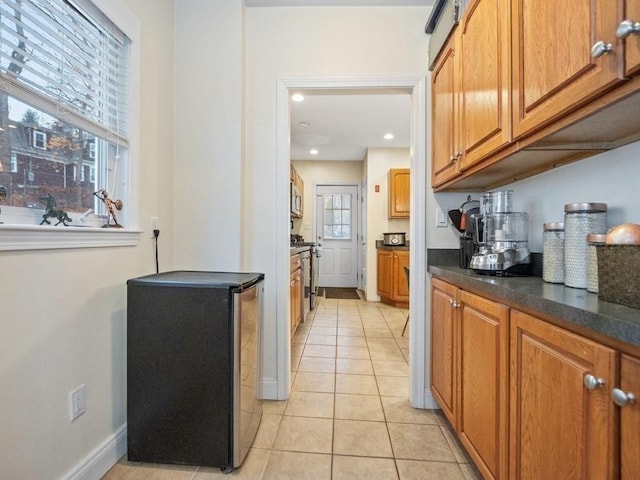 kitchen featuring light tile patterned floors, a wealth of natural light, and appliances with stainless steel finishes