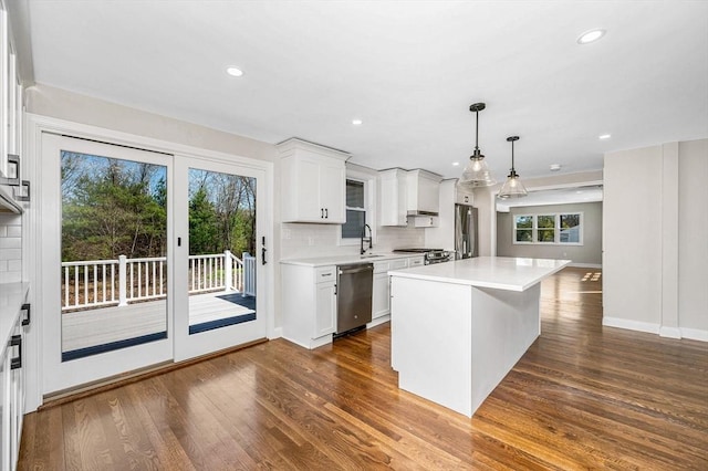 kitchen featuring appliances with stainless steel finishes, tasteful backsplash, dark wood finished floors, light countertops, and white cabinets