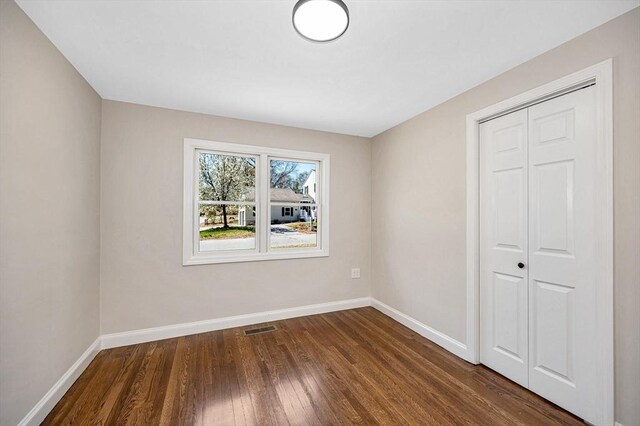 interior space with visible vents, baseboards, dark wood-style flooring, and a closet