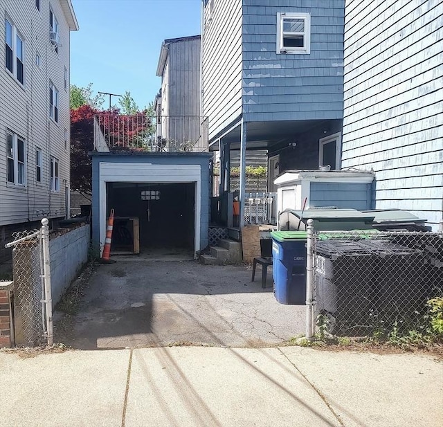 61-63 Grant St, Somerville, MA 02145 - garage featuring driveway, fence, and cooling unit