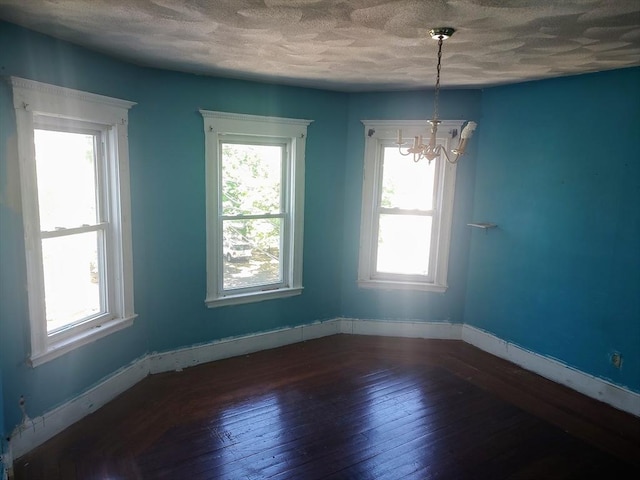 61-63 Grant St, Somerville, MA 02145 - empty room featuring a chandelier, wood-type flooring, baseboards, and a textured ceiling