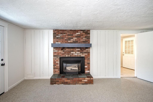 12 Beverly Cir, Randolph, MA 02368 - unfurnished living room featuring carpet flooring, a textured ceiling, baseboards, a fireplace, and a decorative wall