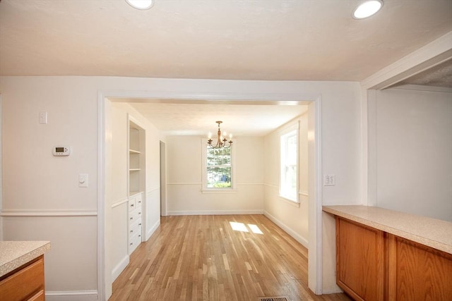 12 Beverly Cir, Randolph, MA 02368 - unfurnished dining area with light wood-style floors, baseboards, and a chandelier