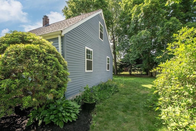 12 Beverly Cir, Randolph, MA 02368 - view of side of home with a chimney, a yard, and roof with shingles