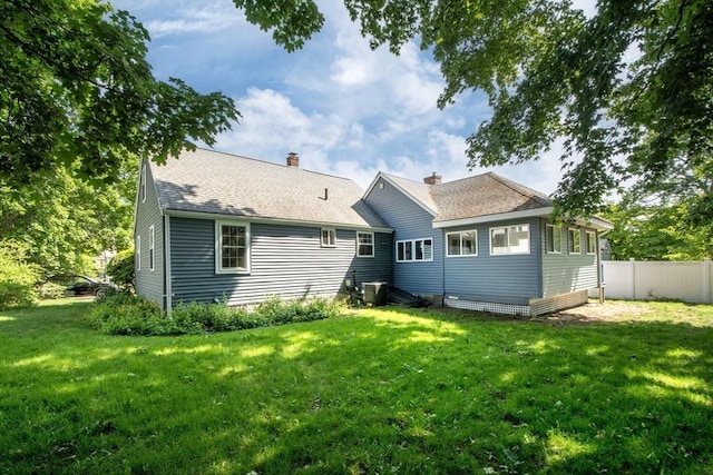 12 Beverly Cir, Randolph, MA 02368 - back of property featuring a chimney, roof with shingles, and central AC unit