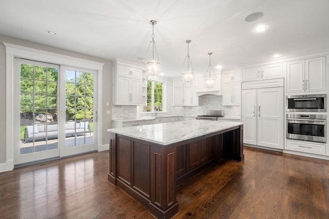27 Covered Bridge Ln, Wayland, MA 01778 - kitchen with decorative backsplash, a sink, white cabinetry, a kitchen island, and dark wood finished floors
