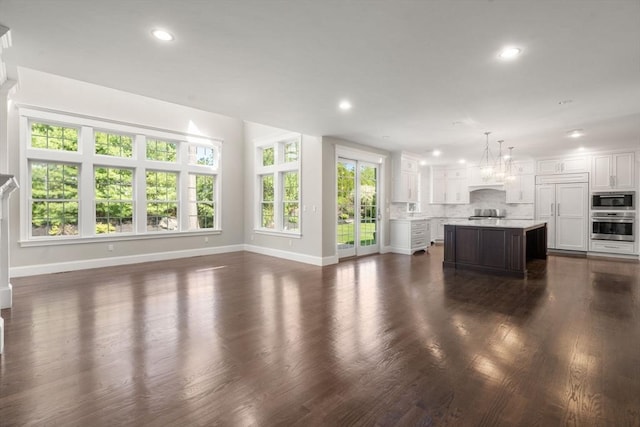 27 Covered Bridge Ln, Wayland, MA 01778 - unfurnished living room with baseboards, dark wood-style flooring, recessed lighting, and a sink