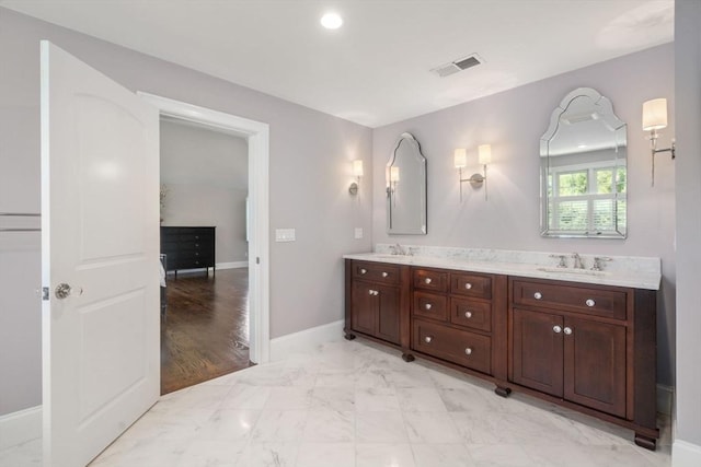 27 Covered Bridge Ln, Wayland, MA 01778 - bathroom featuring double vanity, marble look tile flooring, baseboards, and recessed lighting