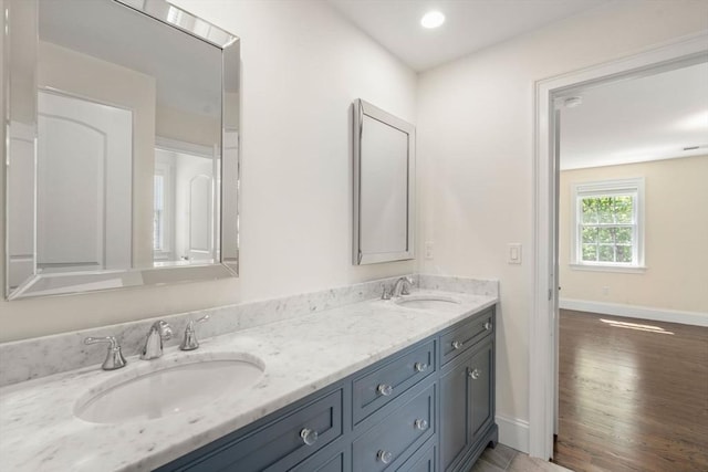 27 Covered Bridge Ln, Wayland, MA 01778 - bathroom with double vanity, wood finished floors, and baseboards