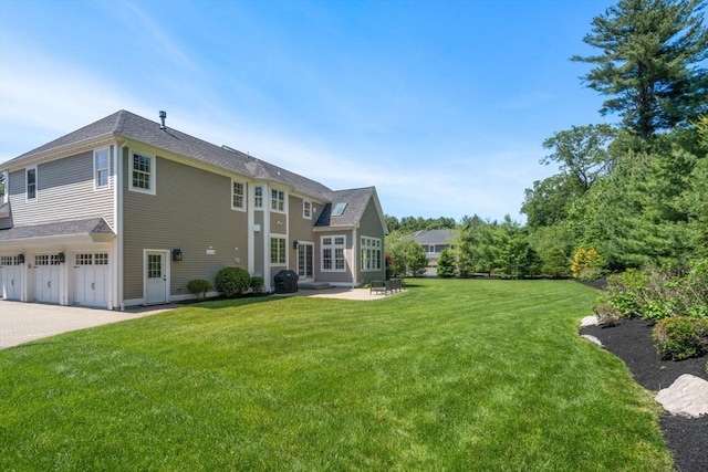 27 Covered Bridge Ln, Wayland, MA 01778 - rear view of property featuring an attached garage, a yard, a patio area, and driveway
