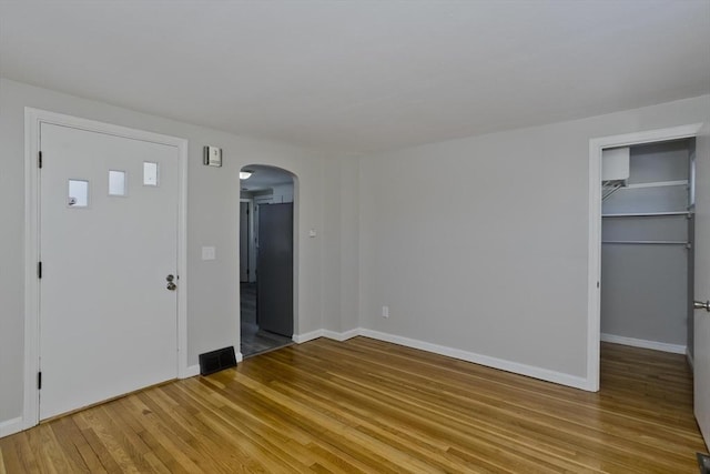 unfurnished bedroom featuring a walk in closet and light wood-type flooring