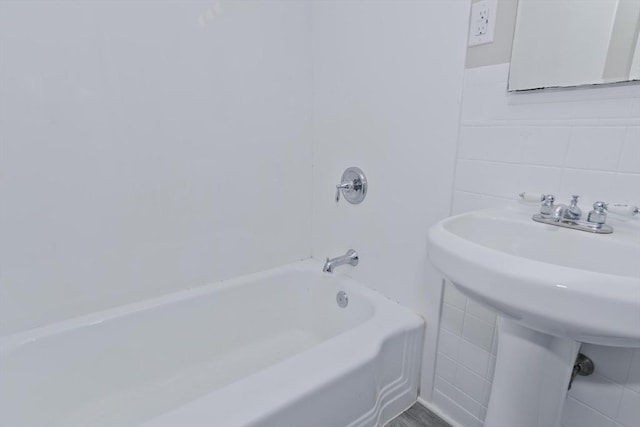 bathroom featuring sink and tile walls