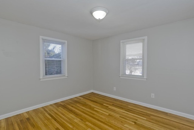 empty room with plenty of natural light and light hardwood / wood-style floors