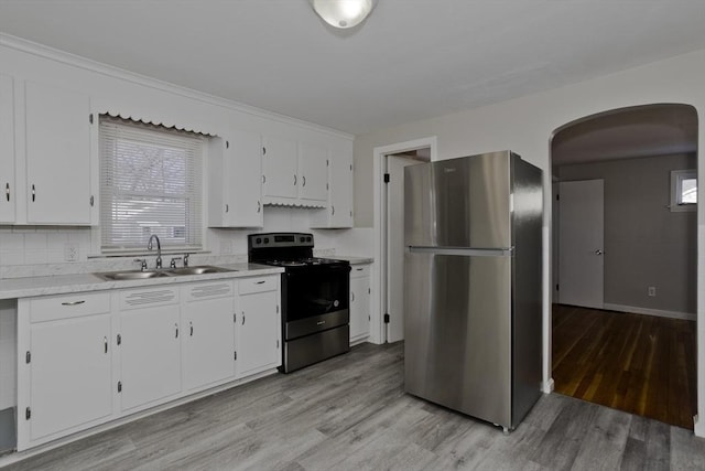 kitchen with appliances with stainless steel finishes, sink, and white cabinets