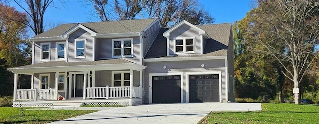 view of front of house featuring a garage, a front lawn, and a porch