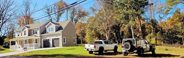 exterior space featuring a porch, a garage, and a front lawn