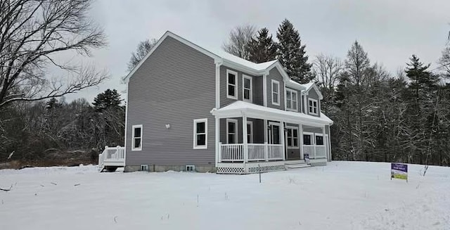 snow covered property featuring a porch