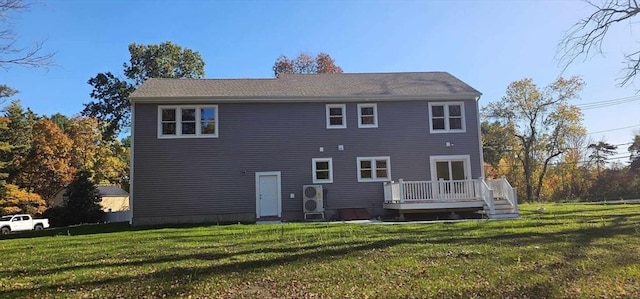 rear view of property featuring a wooden deck and a lawn