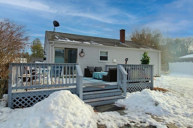 snow covered property with a deck and a chimney