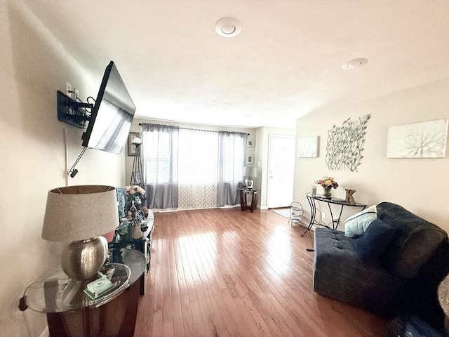 living area featuring baseboards and hardwood / wood-style floors