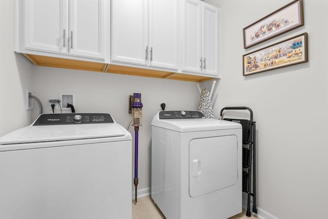 washroom with separate washer and dryer and cabinets