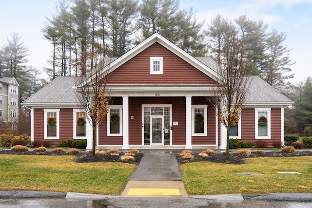 view of front of home featuring covered porch and a front lawn