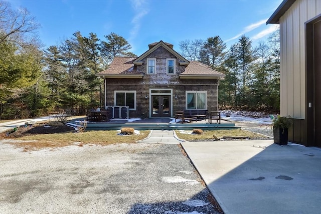 exterior space featuring a patio, french doors, and roof with shingles