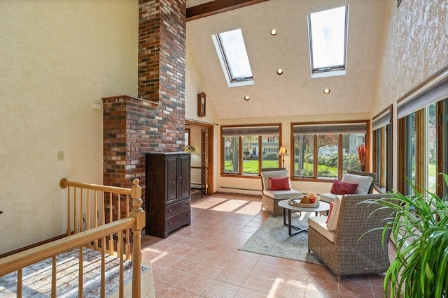 living area with high vaulted ceiling, a baseboard heating unit, and a skylight