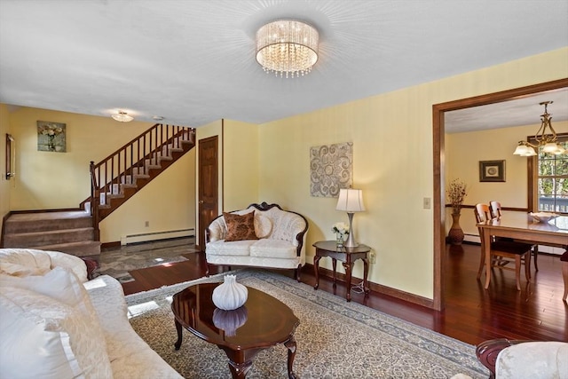 living room with a chandelier, a baseboard heating unit, wood finished floors, and stairway